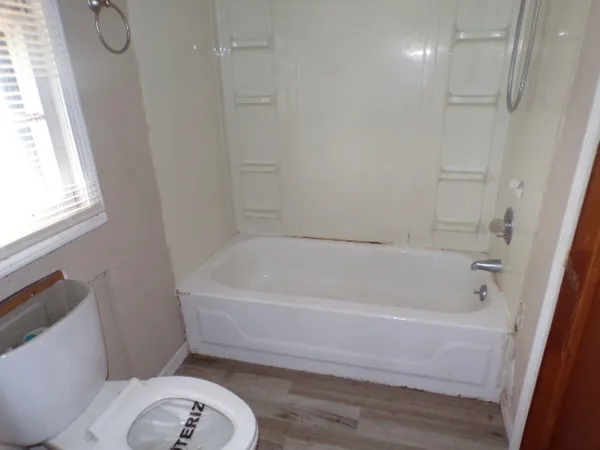 a white bath tub sitting next to a toilet