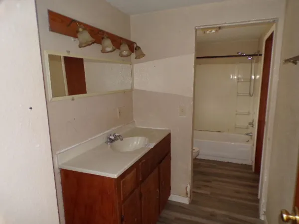 a bathroom with a shower sink and mirror
