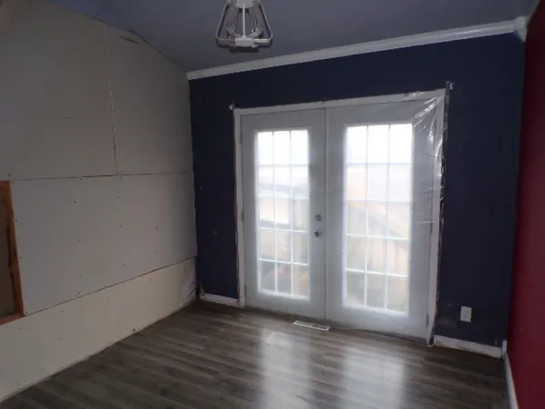 a view of wooden floor chandelier and windows in a room