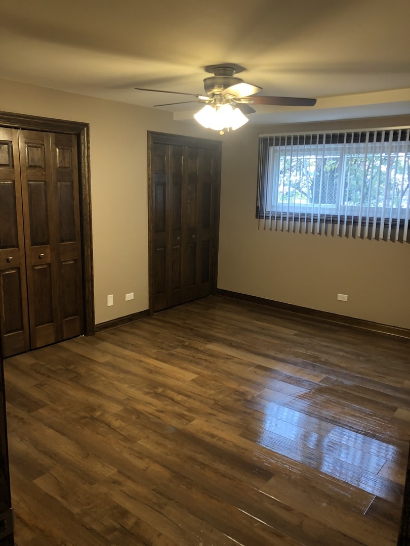 10301 McVicker Avenue Chicago Ridge, IL 60415 - Photo 4 of 21 a view of an empty room with wooden floor and a window