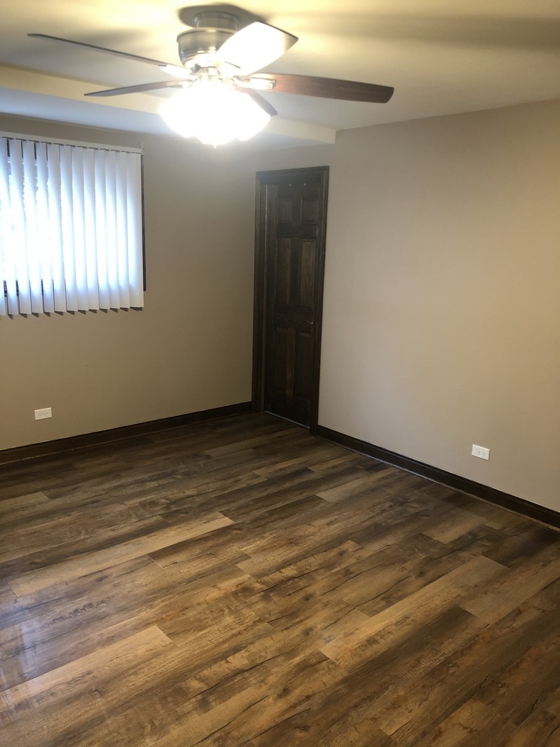 10301 McVicker Avenue Chicago Ridge, IL 60415 - Photo 10 of 21 a view of an empty room with wooden floor and a window