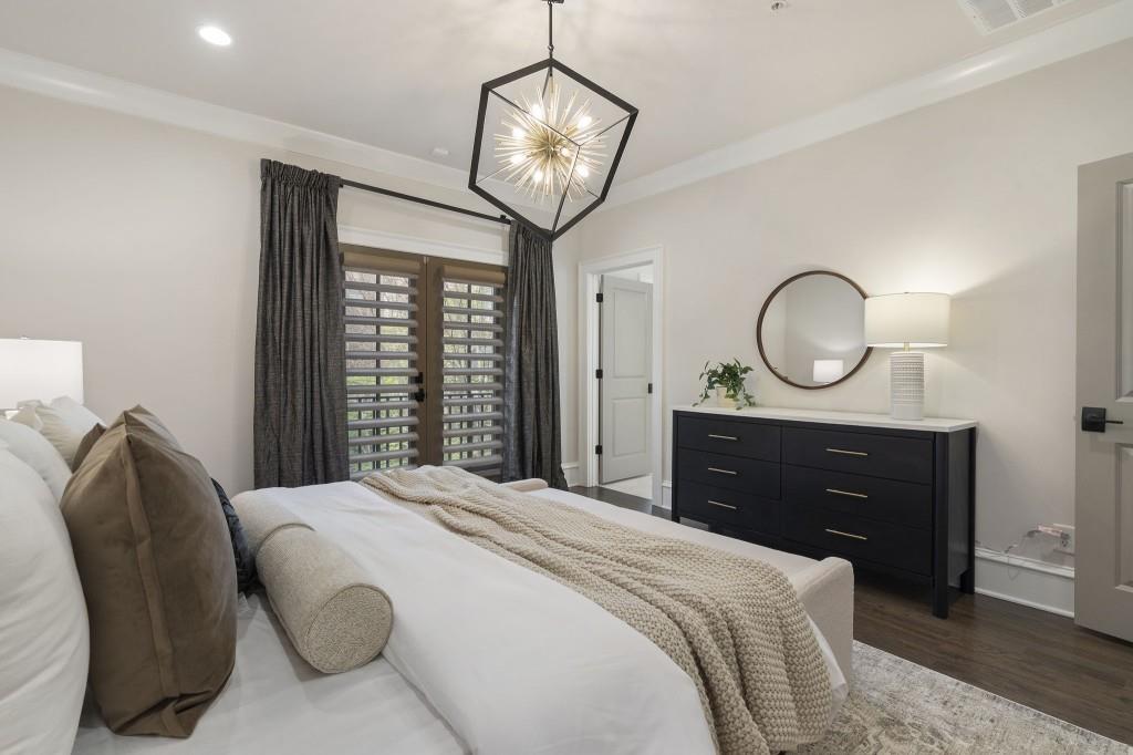 3715 Peachtree Road Northeast, Unit 12 Atlanta, GA 30319 - Photo 29 of 62 a bedroom with a bed a mirror and a chandelier