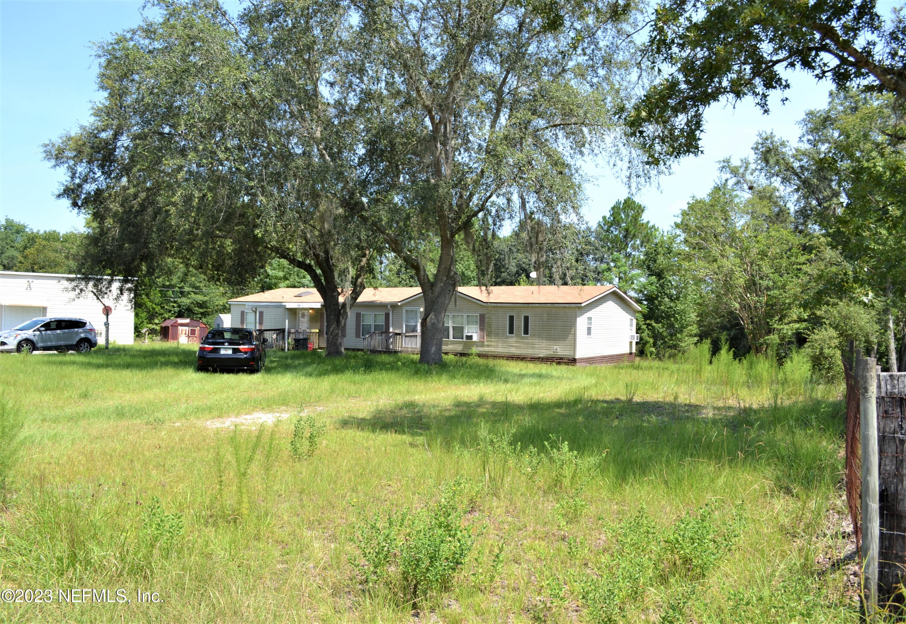 4520 Racoon Run Middleburg, FL 32068 - Photo 15 of 26 a house view with a swimming pool and trees in the background