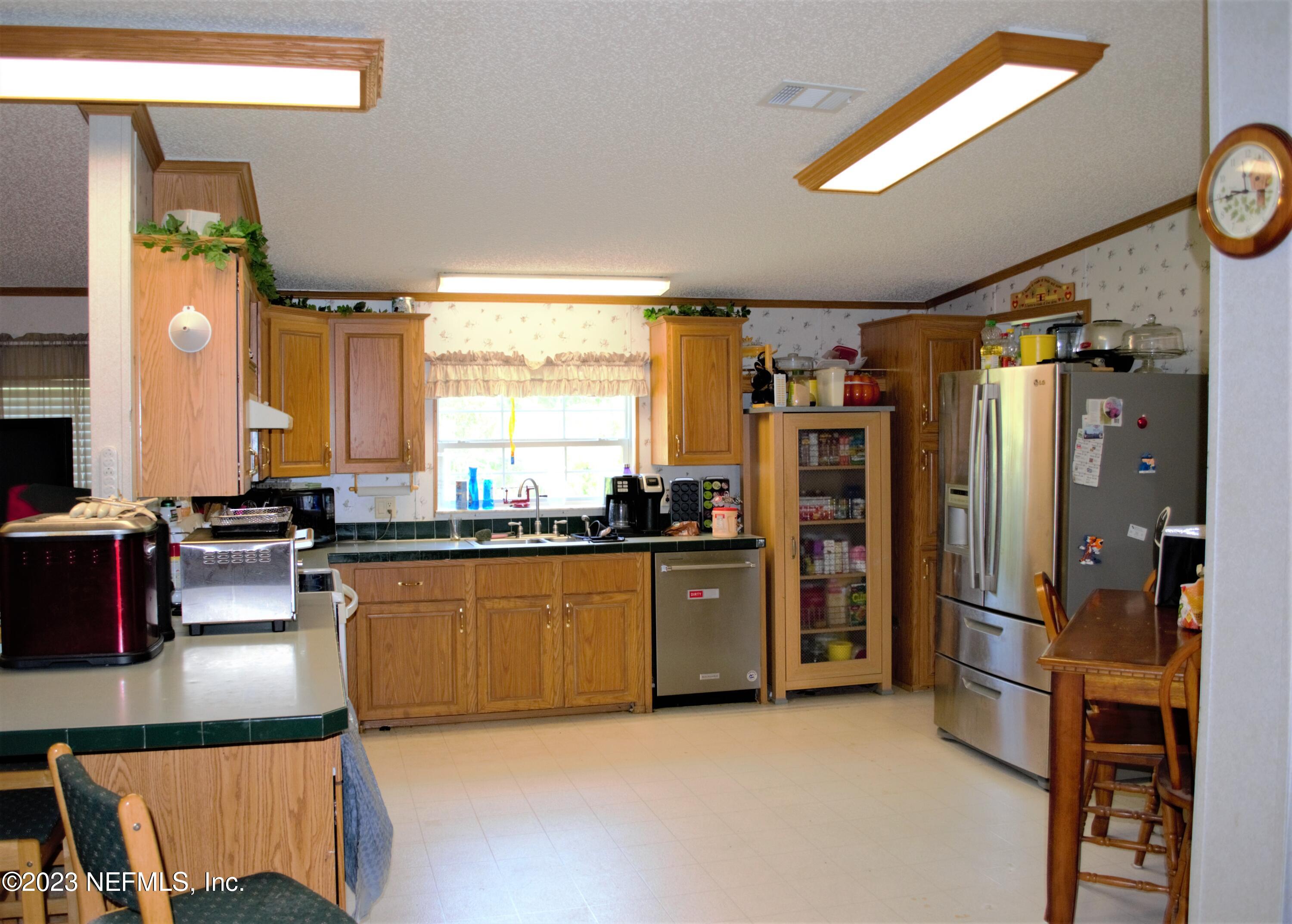 4520 Racoon Run Middleburg, FL 32068 - Photo 4 of 26 a kitchen with stainless steel appliances granite countertop a refrigerator and a stove