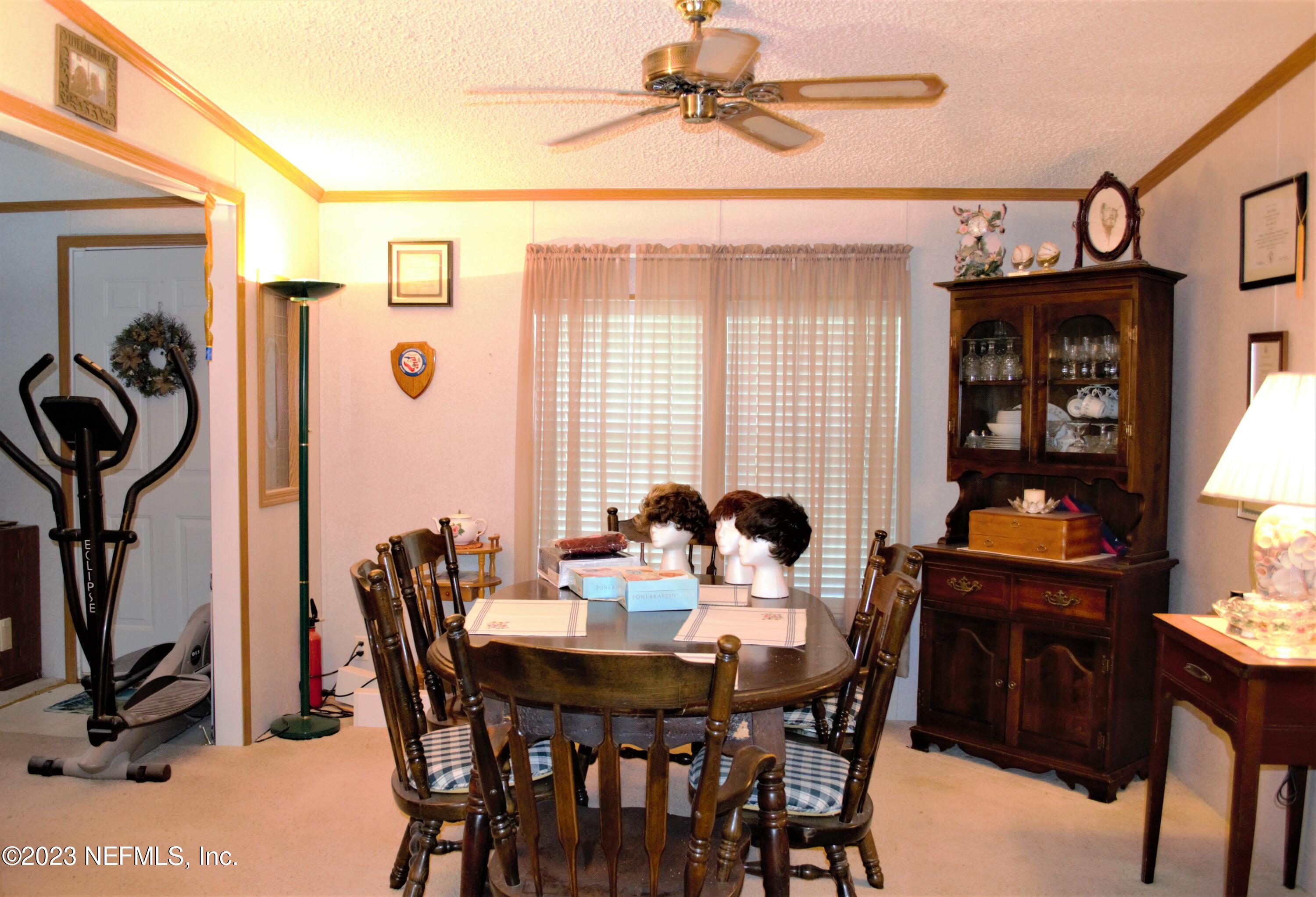 4520 Racoon Run Middleburg, FL 32068 - Photo 5 of 26 a view of a dining room and livingroom with furniture wooden floor a chandelier