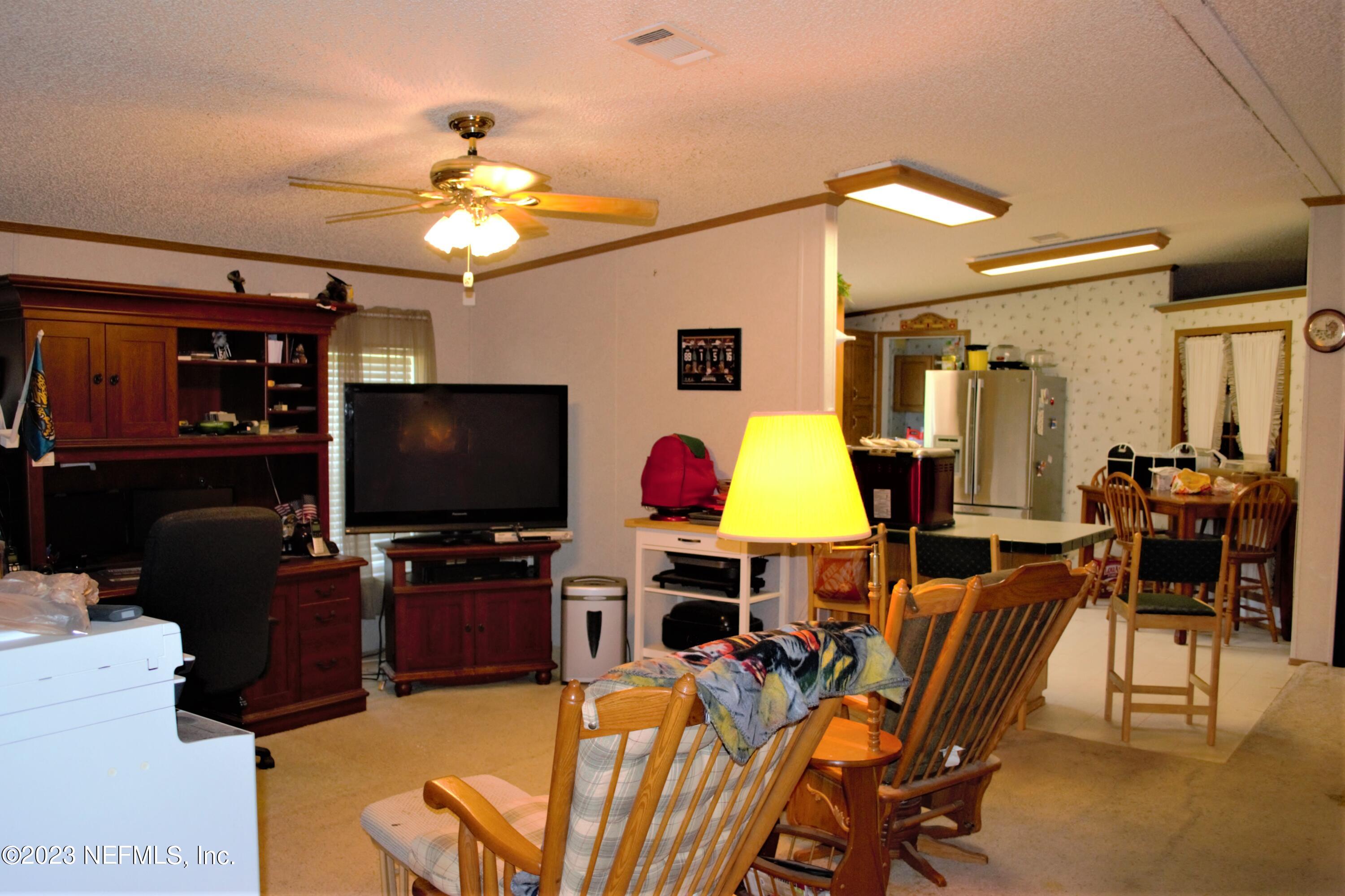 4520 Racoon Run Middleburg, FL 32068 - Photo 7 of 26 a living room with furniture a flat screen tv and dining table