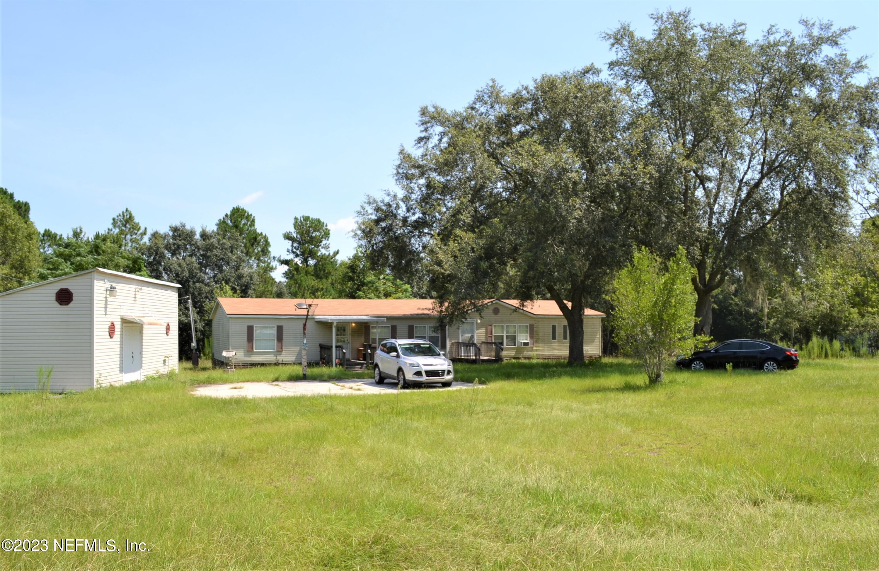 4520 Racoon Run Middleburg, FL 32068 - Photo 10 of 26 a view of a house with a big yard and large trees