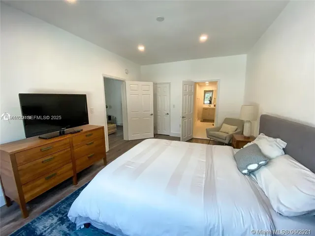 a bedroom with furniture and a flat screen tv