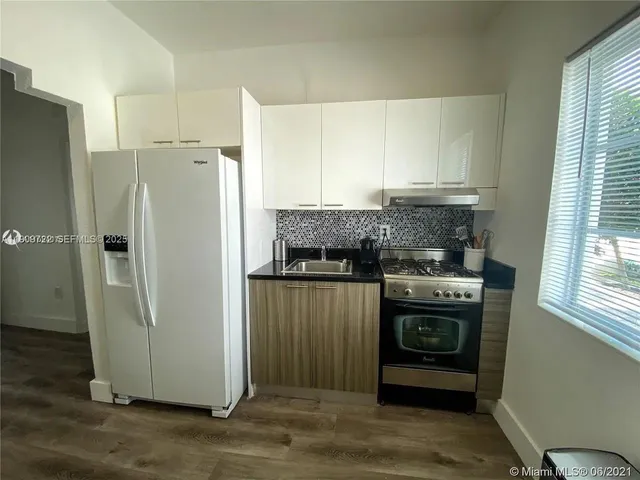 a kitchen with stainless steel appliances granite countertop a refrigerator and a stove