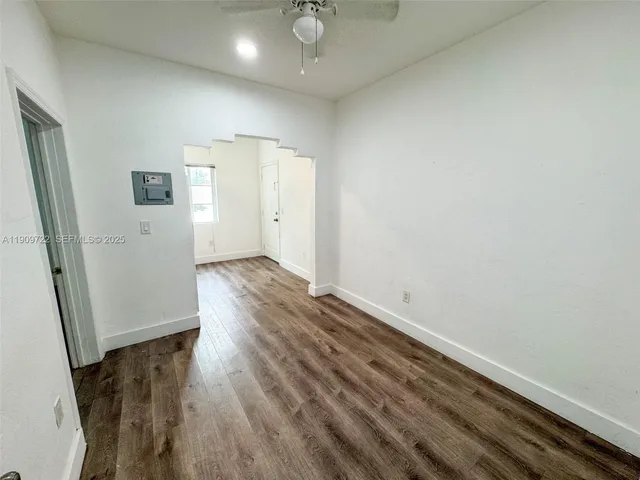 an empty room with wooden floor and entrance