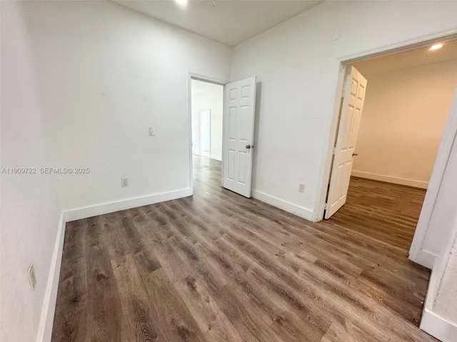a view of a room with wooden floor