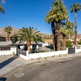 a view of a street with a building and palm trees