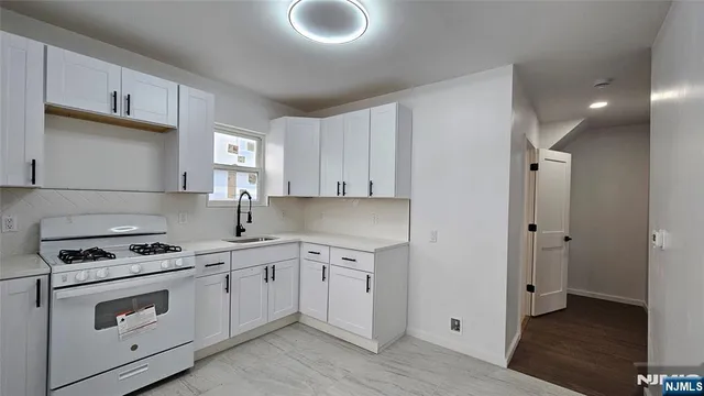a kitchen with cabinets appliances a sink and a counter space