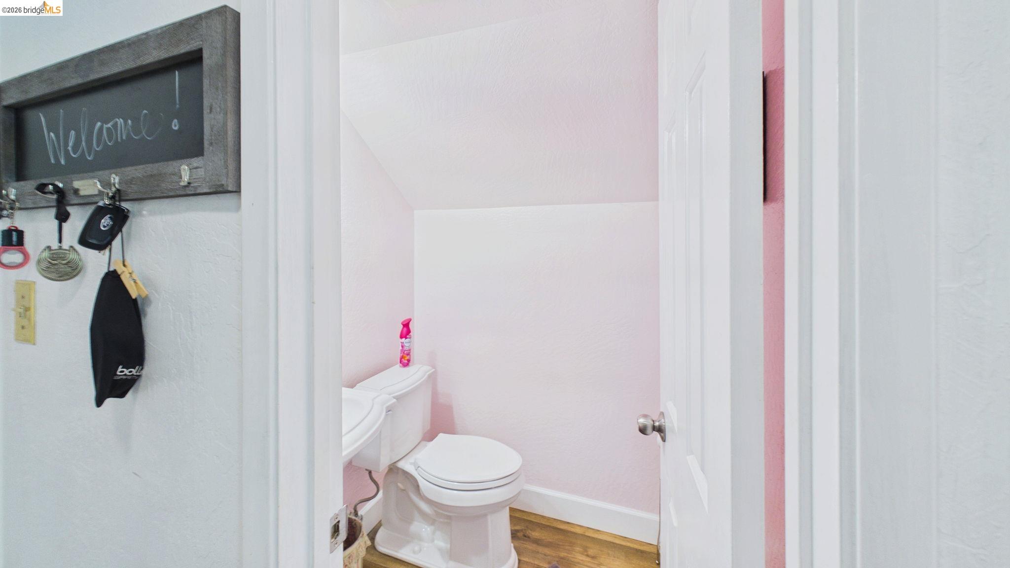11858 Campo Seco Road Sonora, CA 95370 - Photo 23 of 45 Compact powder room with a white toilet, wood-finish flooring, and white baseboards