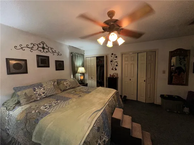 a spacious bedroom with a bed and a chandelier