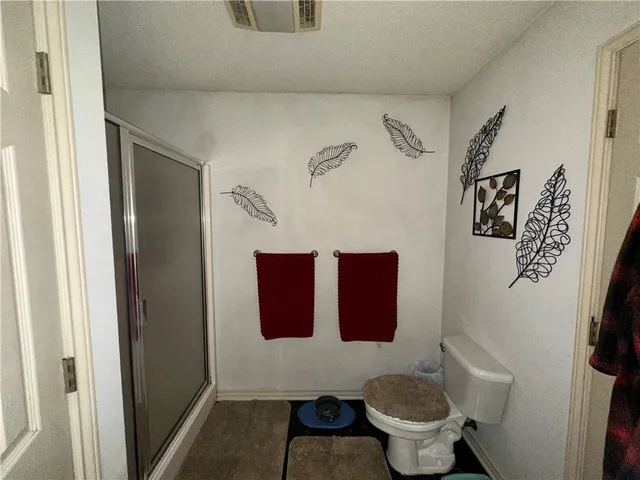 a bathroom with a toilet and a shower curtain