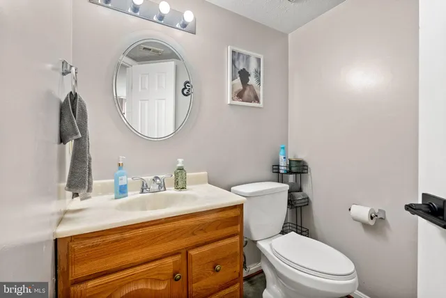 a bathroom with a toilet a sink and mirror