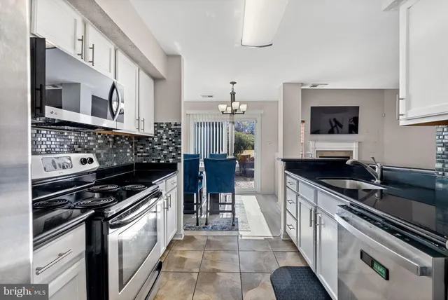 a kitchen with stainless steel appliances a sink dishwasher stove top oven and cabinets
