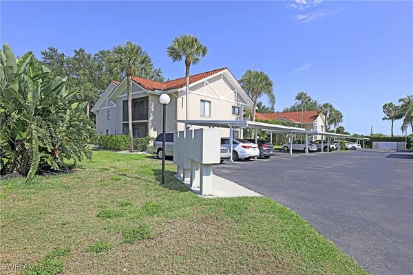 a view of a house with table and chairs in a yard