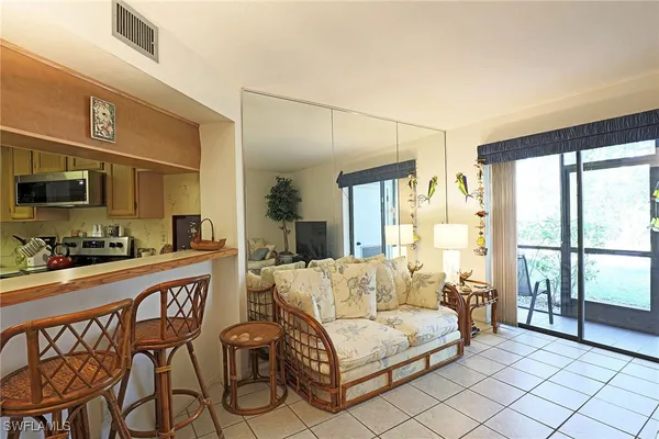 a living room with furniture a flat screen tv and a floor to ceiling window