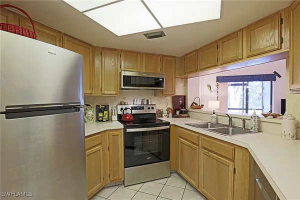a kitchen with a sink a refrigerator and cabinets
