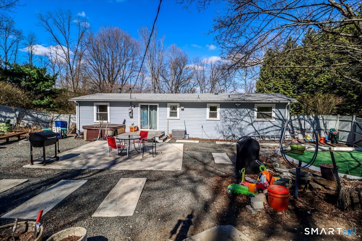 61 Pumpkin Hill Road New Milford, CT 06776 - Photo 36 of 40 a view of a patio with table and chairs under an umbrella