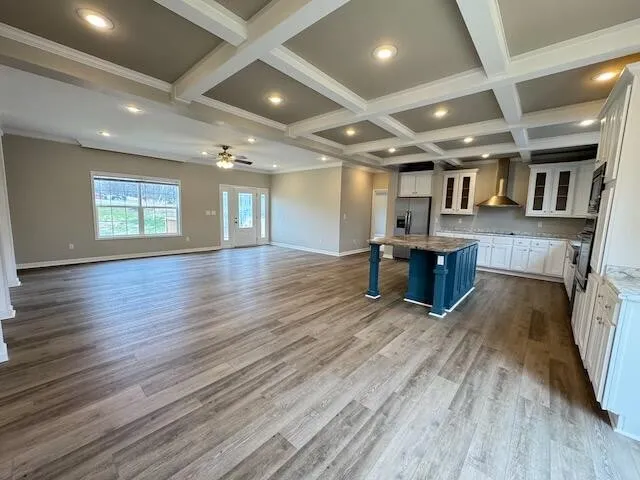 an empty room with wooden floors and windows