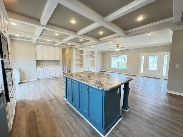 an open kitchen with a wooden floor and entryway