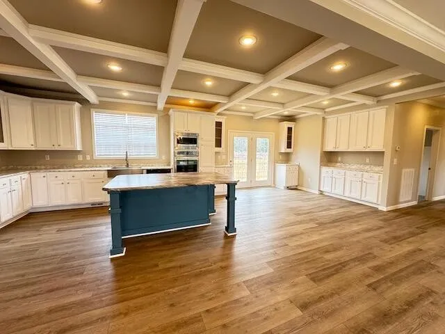 a large kitchen with stainless steel appliances kitchen island granite countertop a large cabinets a sink and a counter top space