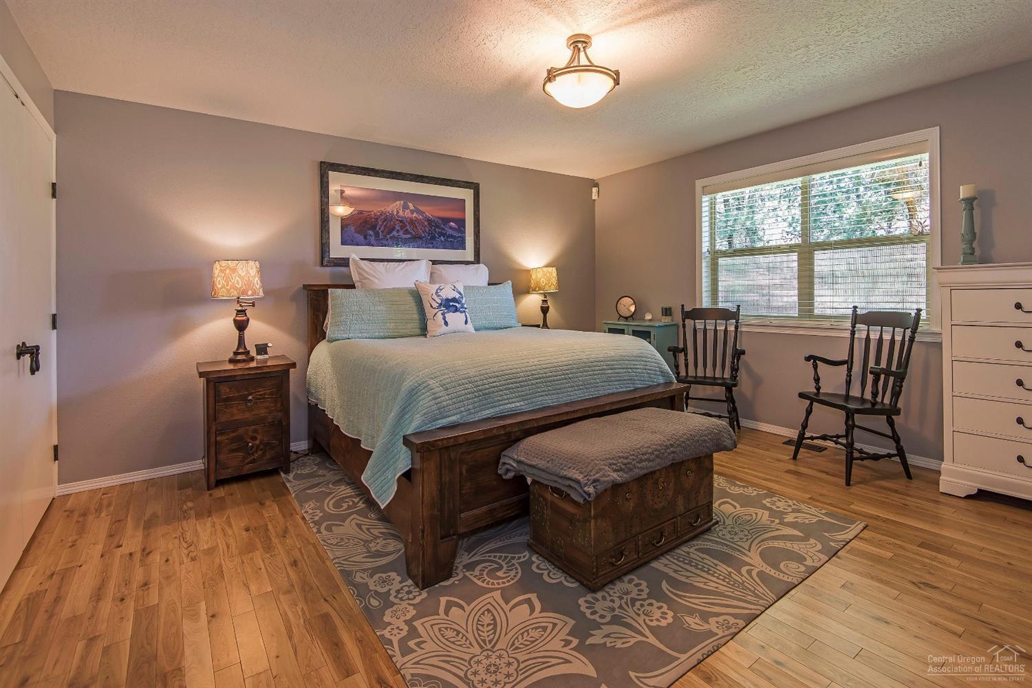20328 Donkey Sled Road Bend, OR 97702 - Photo 9 of 25 a bedroom with a bed and wooden floor