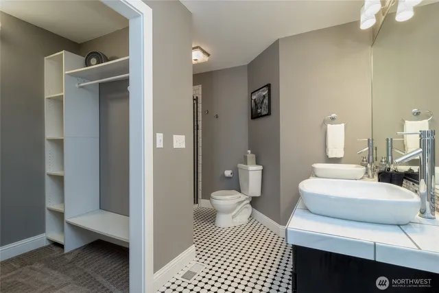 a bathroom with a toilet a sink and mirror