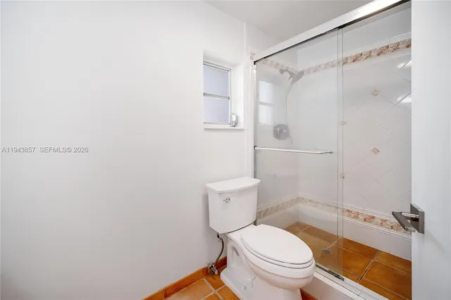a white toilet sitting next to a bathroom sink and a shower