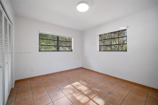 an empty room with windows and painted walls