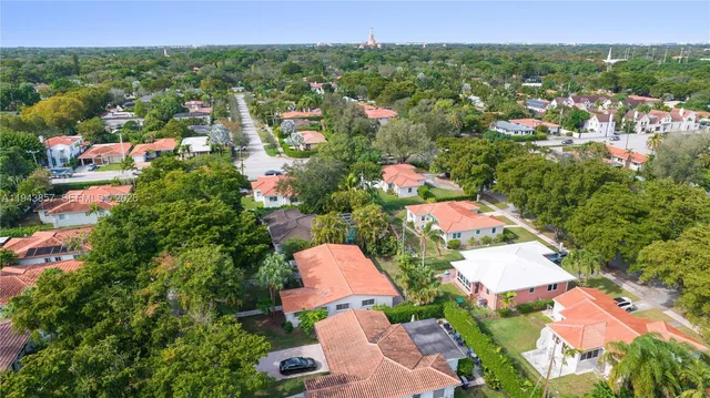an aerial view of residential houses with outdoor space and trees all around