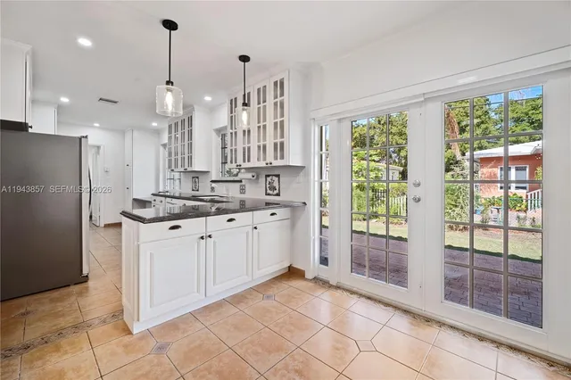 a kitchen with stainless steel appliances granite countertop a refrigerator a sink a oven and a large window