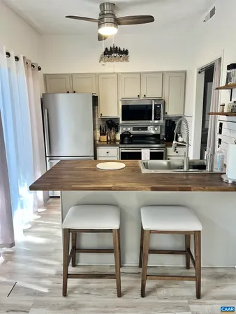 a kitchen with kitchen island a counter top space appliances and cabinets