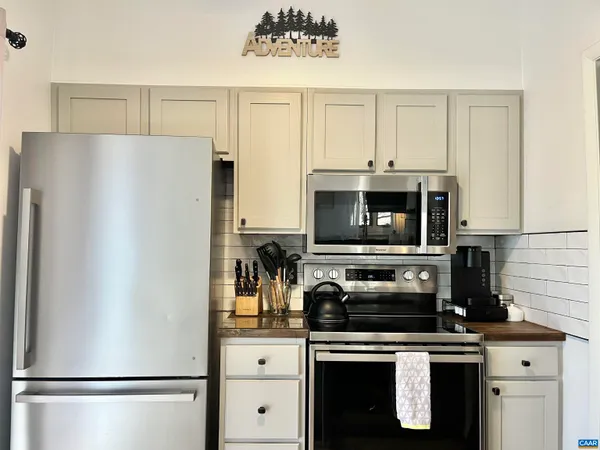 a kitchen with stainless steel appliances a refrigerator stove and microwave