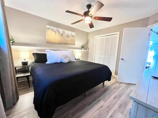 a bedroom with a large bed and a ceiling fan