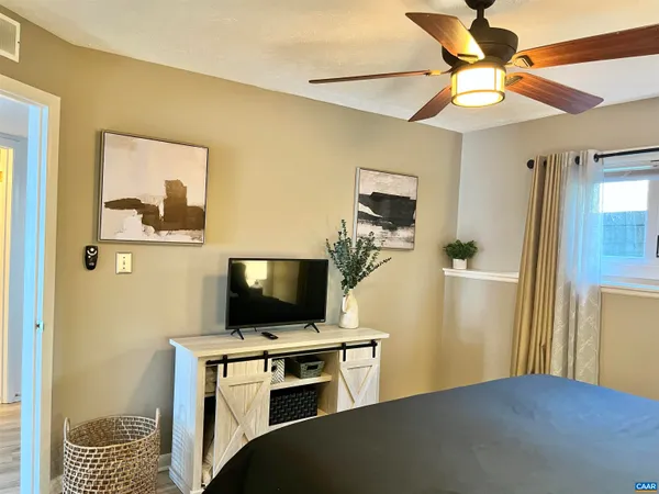 a bedroom with a bed and a flat screen tv