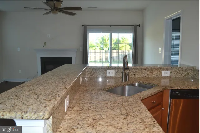 a kitchen with granite countertop wood cabinets stainless steel appliances and a window