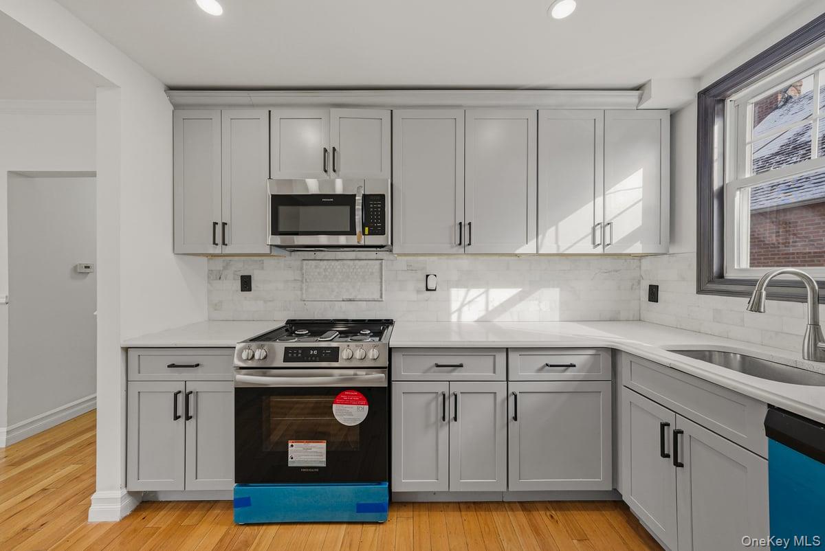 118-27 201st Street Queens, NY 11412 - Photo 12 of 36 a kitchen with granite countertop a stove a sink and a microwave