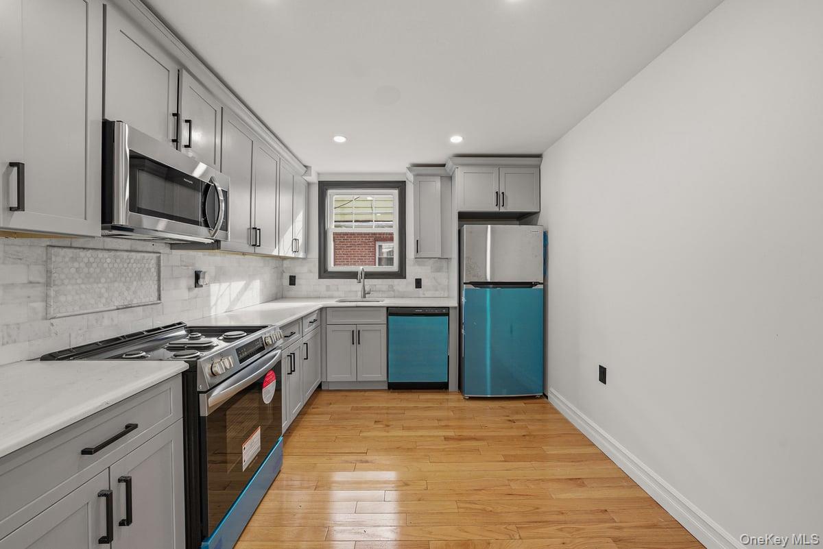 118-27 201st Street Queens, NY 11412 - Photo 13 of 36 a kitchen with stainless steel appliances granite countertop a stove a sink and a microwave
