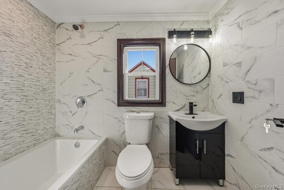 118-27 201st Street Queens, NY 11412 - Photo 15 of 36 a bathroom with a toilet a sink and a bathtub