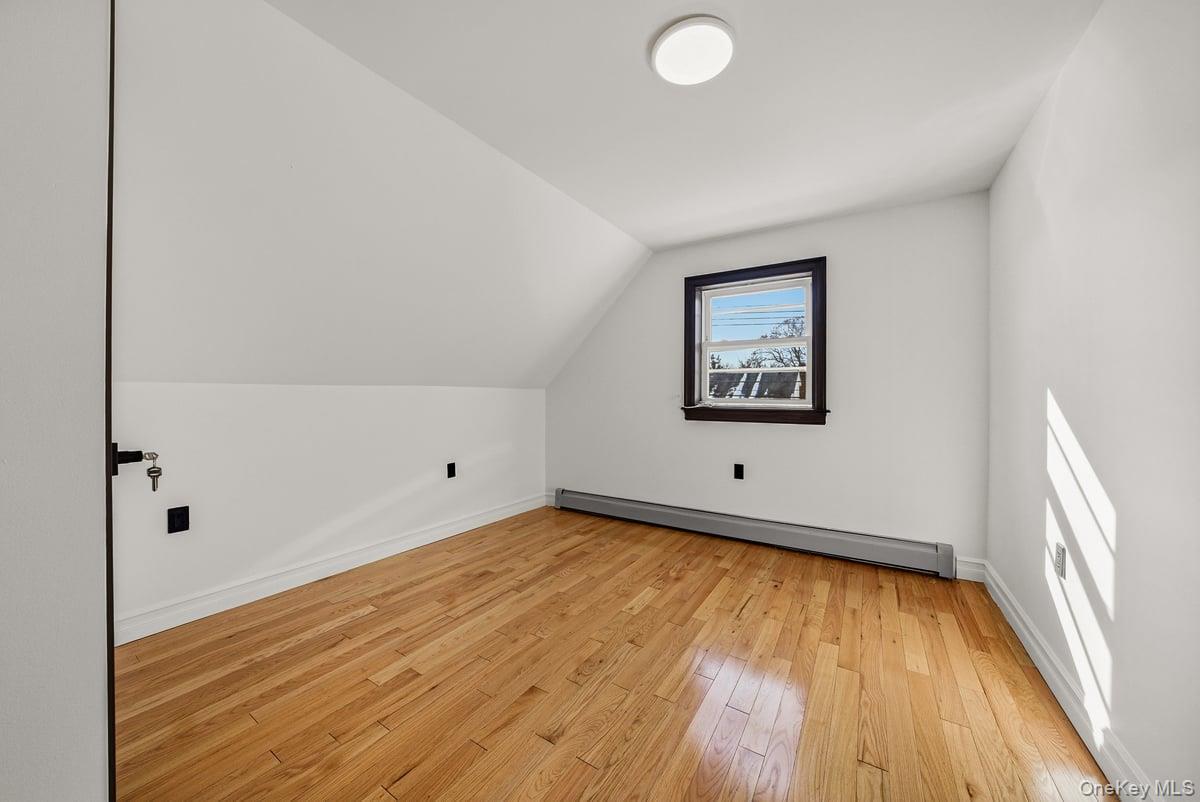 118-27 201st Street Queens, NY 11412 - Photo 16 of 36 a view of a room with wooden floor and white walls