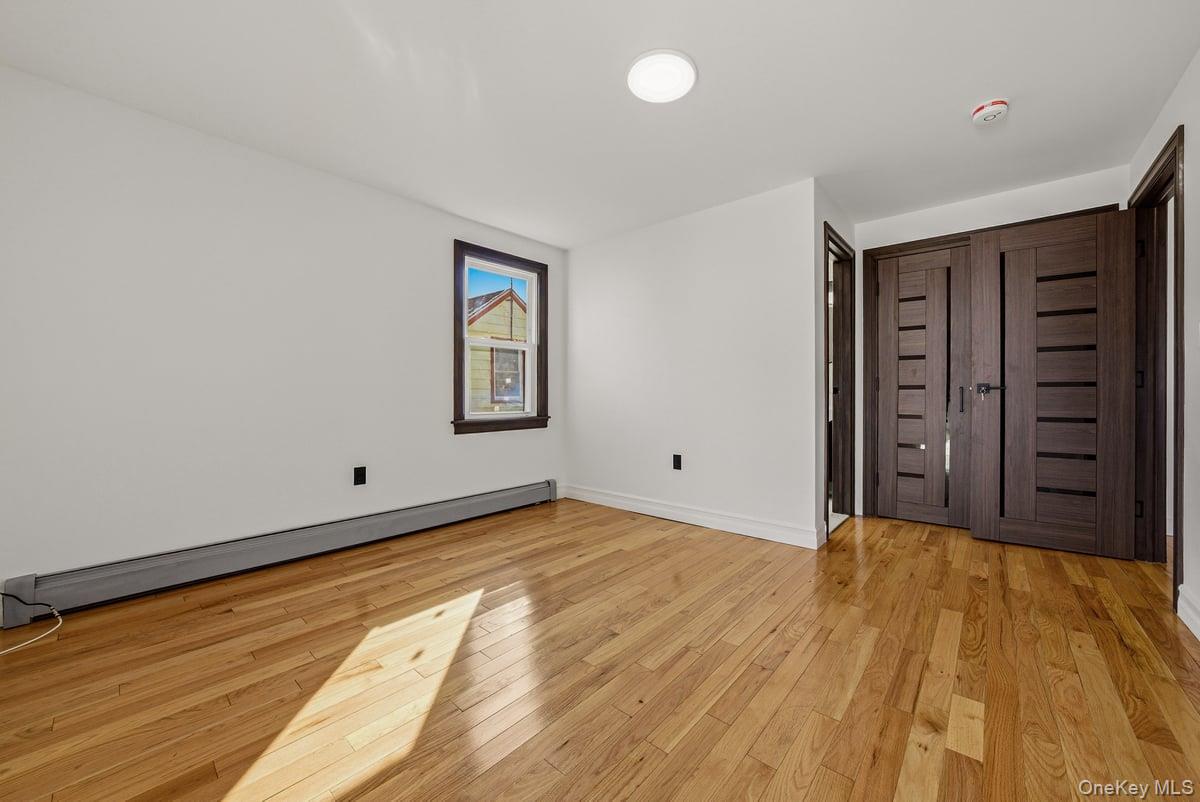 118-27 201st Street Queens, NY 11412 - Photo 21 of 36 a view of a room with an empty space and wooden floor