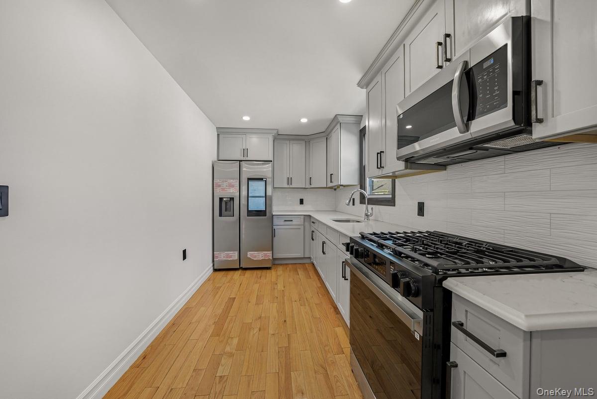 118-27 201st Street Queens, NY 11412 - Photo 23 of 36 a kitchen with stainless steel appliances granite countertop a stove and a sink