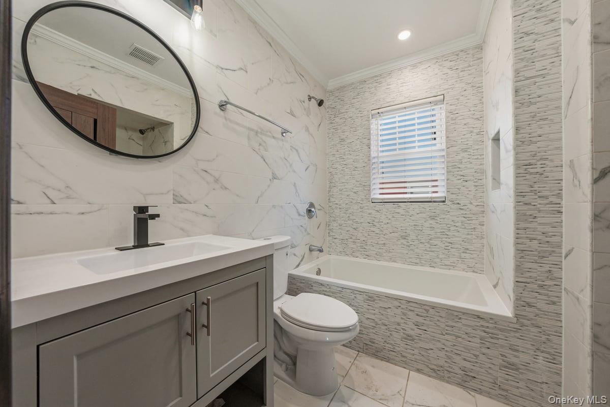 118-27 201st Street Queens, NY 11412 - Photo 7 of 36 a bathroom with a sink a toilet and a mirror