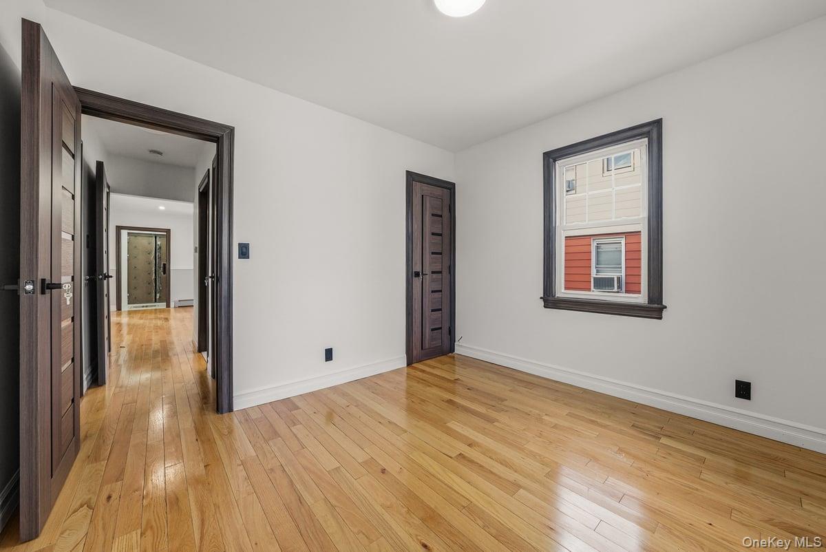 118-27 201st Street Queens, NY 11412 - Photo 9 of 36 a view of a room with wooden floor and a bathroom