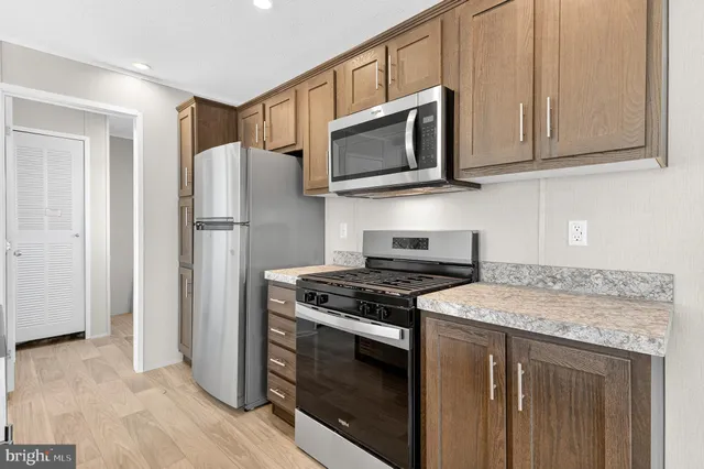 a kitchen with stainless steel appliances granite countertop a sink and wooden cabinets