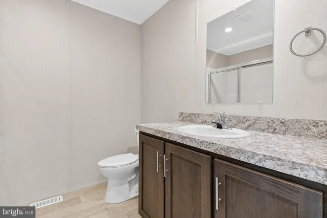 a bathroom with a granite countertop sink a toilet and a mirror
